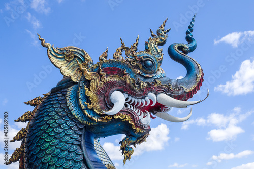 Head of a blue dragon against the sky. Buddhist temple Wat Rong Seur Ten  Blue Temple . Chiang Rai  Thailand