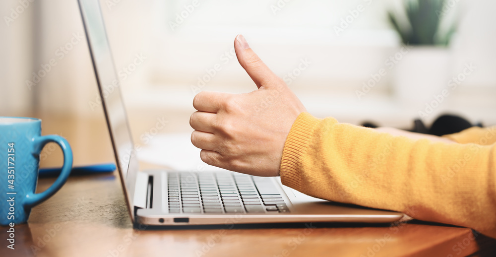 Side view of slim laptop and I like it thumb up hand. Distant learning. working from home, home office or online courses e-learning. vlogger blogger streaming. Happy client banner Side view of slim laptop and I like it thumb up hand. Distant learning. working from home, home office or online courses e-learning. vlogger blogger streaming. Happy client banner