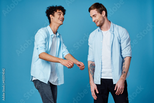 two men on a blue background gesturing with their hands team friendship communication