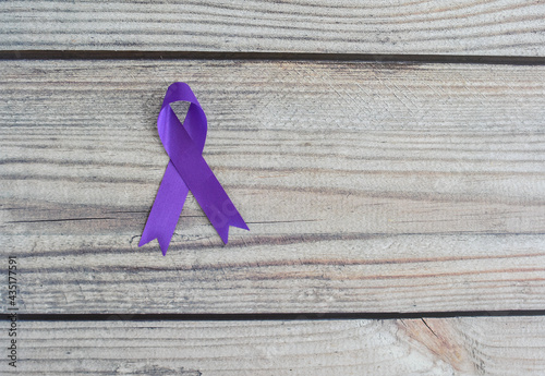 World Cancer Day. International Overdose Awareness Day. The purple ribbon on the wooden table photo