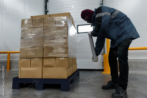 Staff wrapping film packaging boxes at cold storage warehouse, Loading goods prepare storage in the freezing room, Warehouse Storage System Service in Export-Import Logistics Business concept