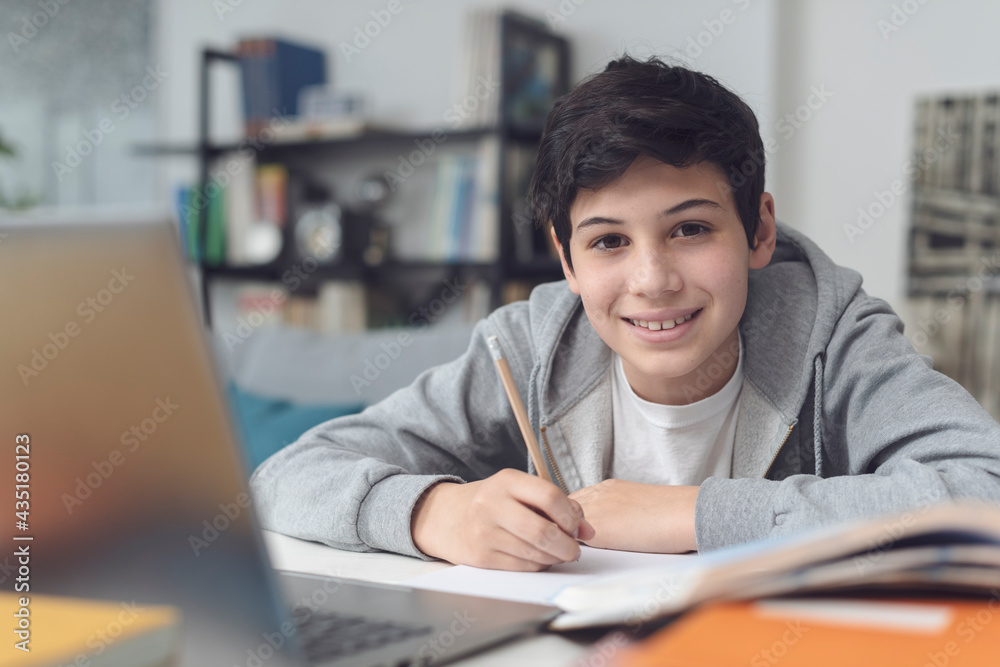 Happy student sitting at desk and studying Happy student sitting at desk and studying