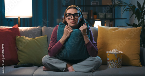 Canvastavla Woman watching a horror movie at home