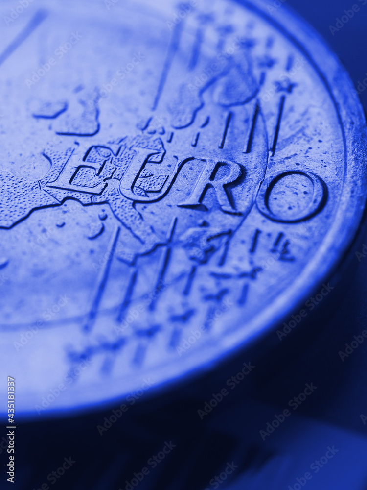 Fragment of a coin of 1 one euro. In focus inscription with the name of the Eurozone currency. Close-up. Blue tinted vertical illustration with euro coin about the European Union. Macro Fragment of a coin of 1 one euro. In focus inscription with the name of the Eurozone currency. Close-up. Blue tinted vertical illustration with euro coin about the European Union. Macro