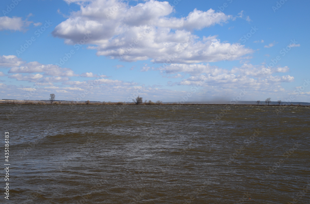 view of the wide river with the horizon and blue sky