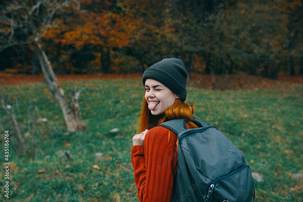 happy traveler resting in nature with backpack on her back back view happy traveler resting in nature with backpack on her back back view