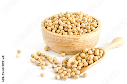Dry organic soybean seeds in wooden bowl and spoon on white background