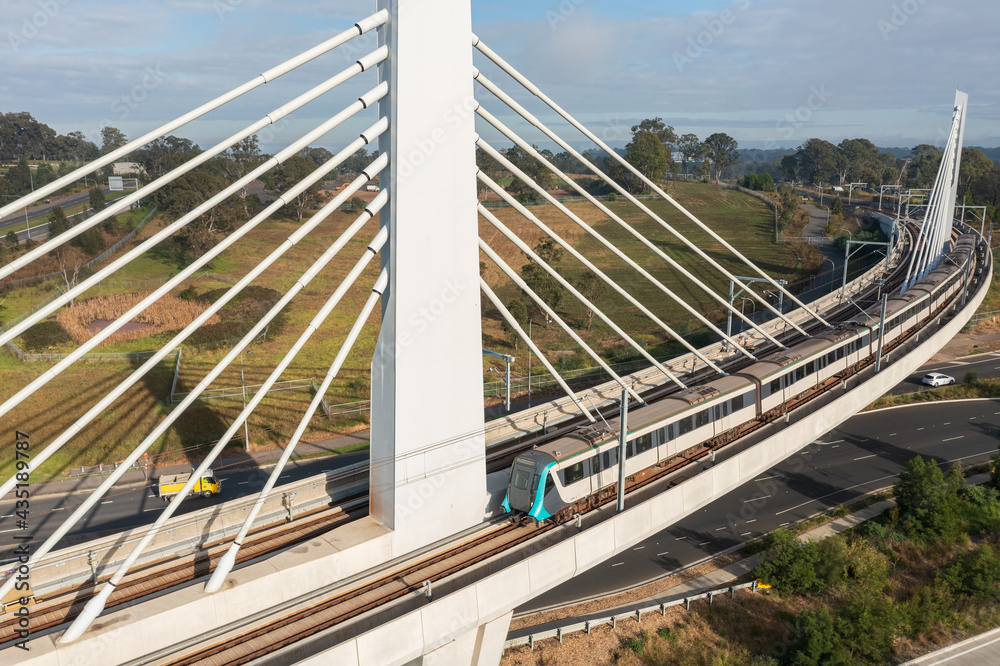 Fototapeta premium A Sydney metro train crosses a bridge over Windsor Road, Rouse Hill, NSW, Australia