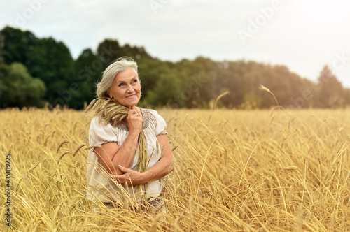 Portrait of a happy smiling senior woman in wheat field