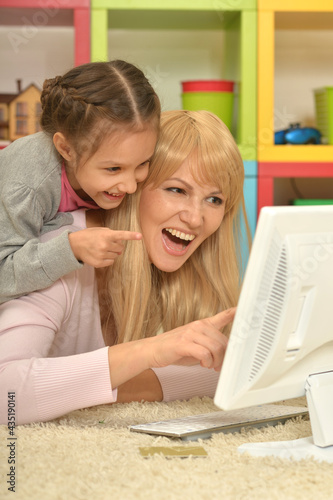 Portrait of mother and daughter using computer