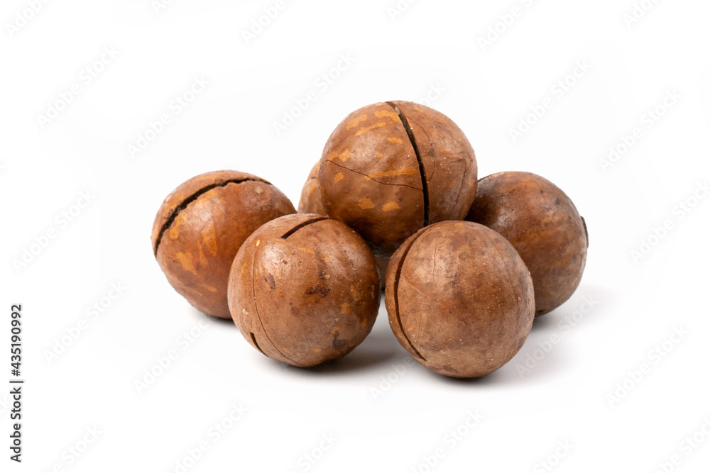 A pile of macadamia nuts in close - up isolated on a white background. A pile of macadamia nuts in close - up isolated on a white background.