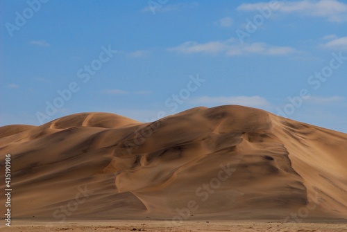 Dunes in the Namibian desert on a sunny day with blue sky and few clouds