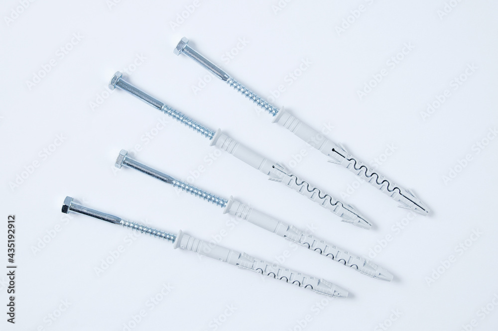 Four metal dowel-nail with  plastic box on a white background.