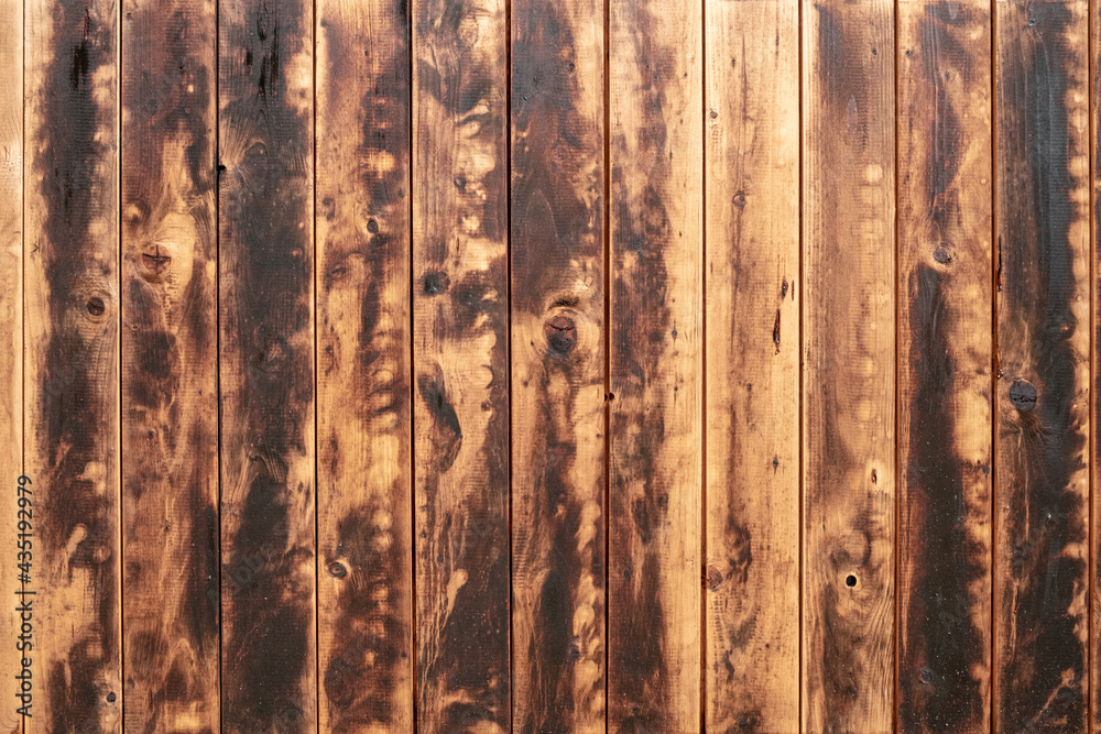Fototapeta premium Texture of an old wooden wall with heavy signs of use as background image.