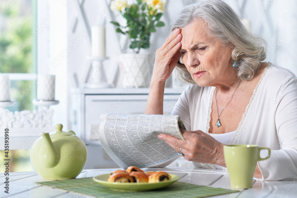 Portrait of senior woman reading newspaper Portrait of senior woman reading newspaper
