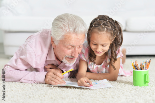 Happy Grandfather with granddaughter drawing together