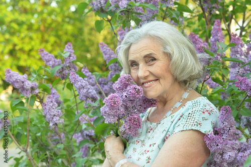 Fotografie happy  senior beautiful woman with lilacs