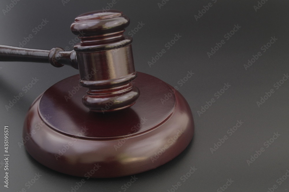 Wooden judge gavel on black table close up, legal and law concept.