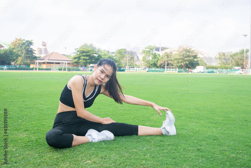 Portrait of beautiful young woman exercising on green grass. female fitness model stretching exercise or warming up before work out. exercise, Fitness, workout, sport, lifestyle concept. Portrait of beautiful young woman exercising on green grass. female fitness model stretching exercise or warming up before work out. exercise, Fitness, workout, sport, lifestyle concept.