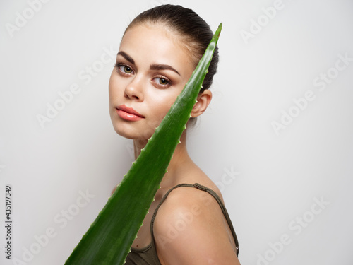 young woman with aloe leaf on light background clean skin t-shirt model 