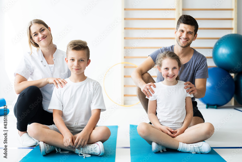 Kids sitting on blue yoga mats with their professional physician