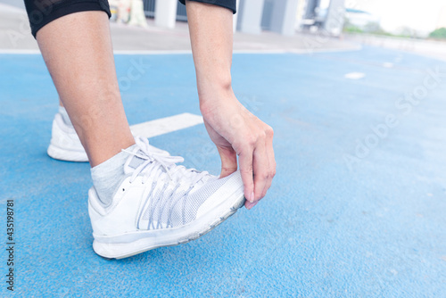 Close up leg of woman stretching exercising on Running Track. female fitness model stretching exercise or warming up before work out. exercise, Fitness, workout, sport, lifestyle concept.