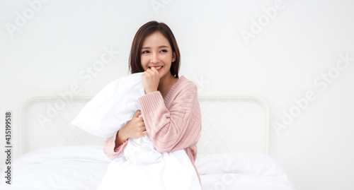 Smiling of cheerful beautiful pretty asian woman clean fresh healthy white skin posing in warm knitted pink clothes.Girl felling relaxing and enjoy time on the bed at home.asia beauty
