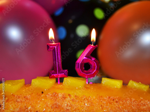 Celebration of the 16th birthday, with candles in the cake and balloons photo