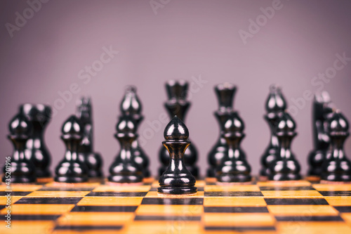 Black pawn  move forward. Selective focus. Strategy. Defense. Sport. Business.