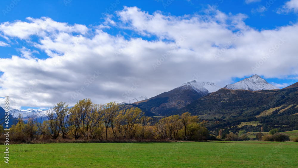 Landscape panorama with autumn trees and snow-capped mountains in the South Island of New Zealand Landscape panorama with autumn trees and snow-capped mountains in the South Island of New Zealand