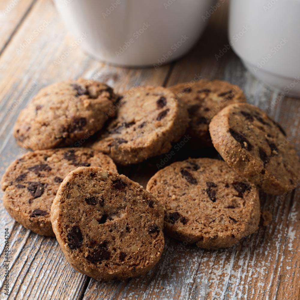 A pile of chocolate chip cookies on a wooden rustic table A pile of chocolate chip cookies on a wooden rustic table