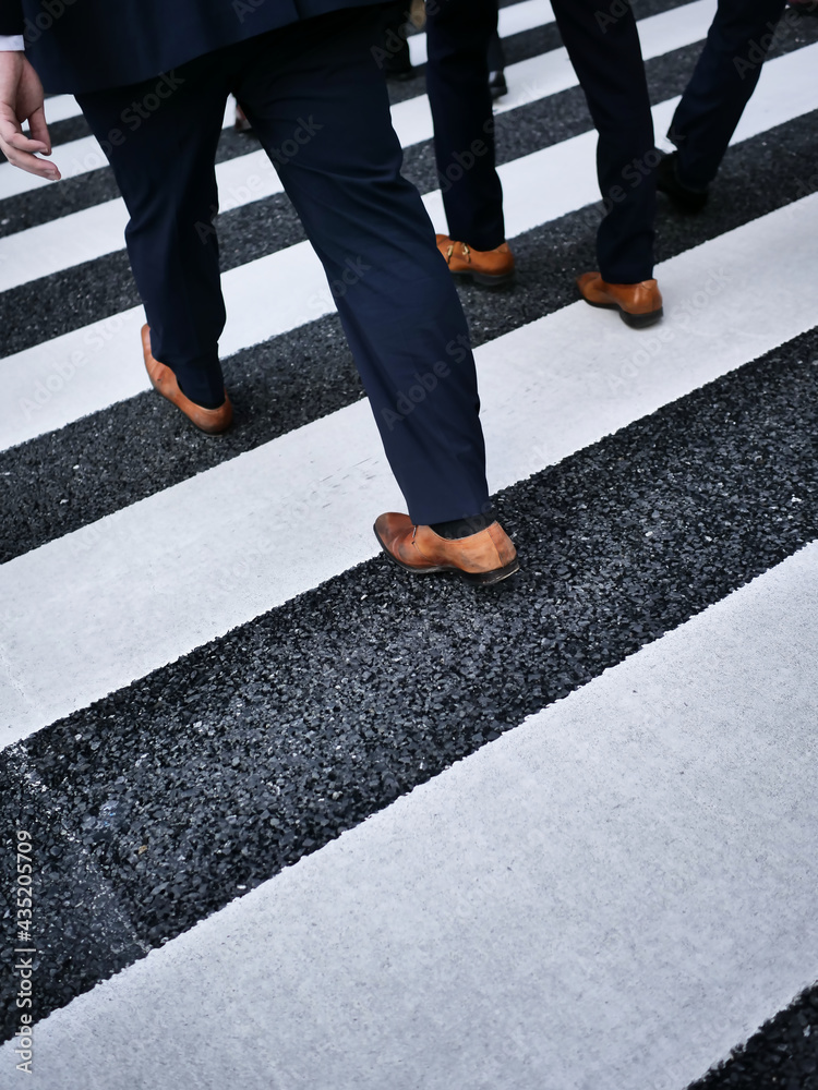 Businessmen legs in dark suit on a street crossing