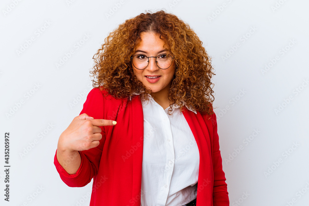 Fototapeta premium Young latin curvy woman isolated on white background person pointing by hand to a shirt copy space, proud and confident