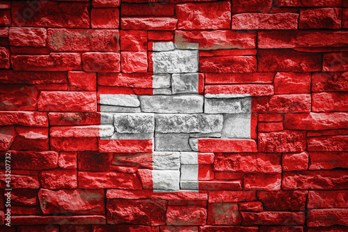 National flag of Switzerland on stone wall background.The concept of national pride and symbol of the country. Flag banner on stone texture background.