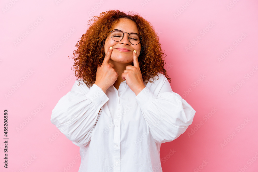 Young latin curvy woman isolated on pink background doubting between two options. Young latin curvy woman isolated on pink background doubting between two options.