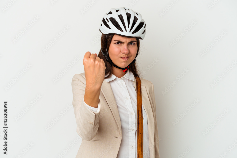 Young caucasian woman riding a bicycle to work isolated on white background showing fist to camera, aggressive facial expression. Young caucasian woman riding a bicycle to work isolated on white background showing fist to camera, aggressive facial expression.