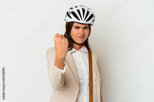 Young caucasian woman riding a bicycle to work isolated on white background showing fist to camera, aggressive facial expression.