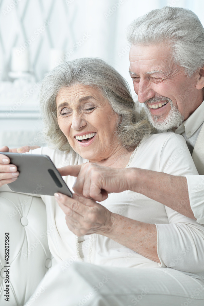 portrait of a happy senior couple using tablet at home portrait of a happy senior couple using tablet at home