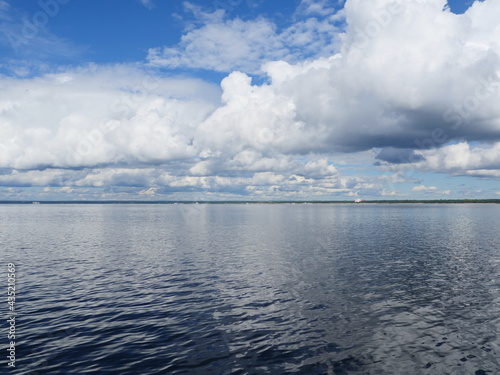 Seascape cumulus clouds and blue sky are reflected in the sea