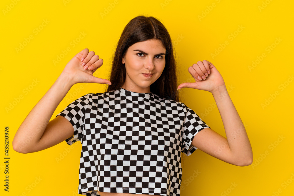 Young caucasian woman isolated on yellow background feels proud and self confident, example to follow.