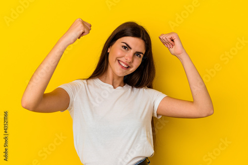 Young caucasian woman isolated on yellow background celebrating a special day, jumps and raise arms with energy.