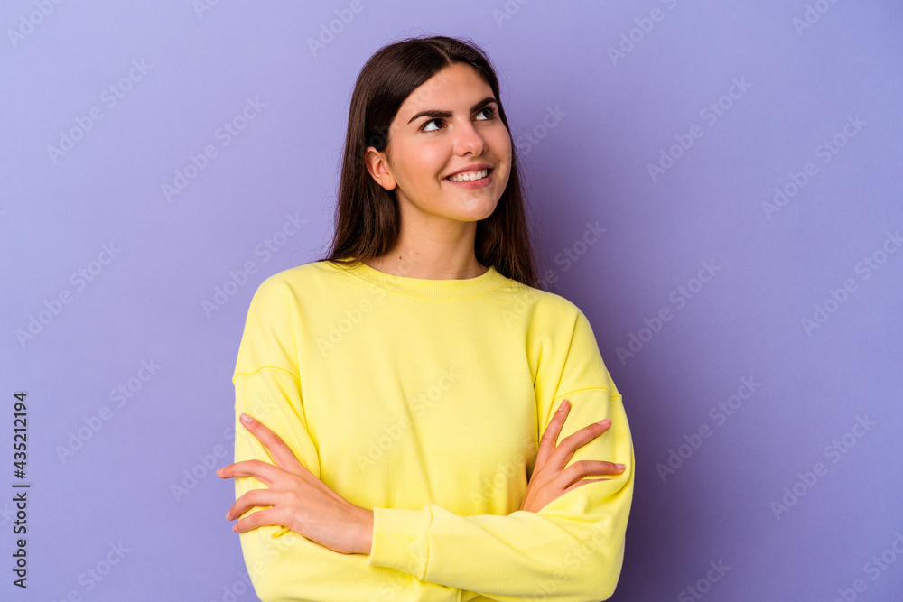 Obraz premium Young caucasian woman isolated on purple background dreaming of achieving goals and purposes