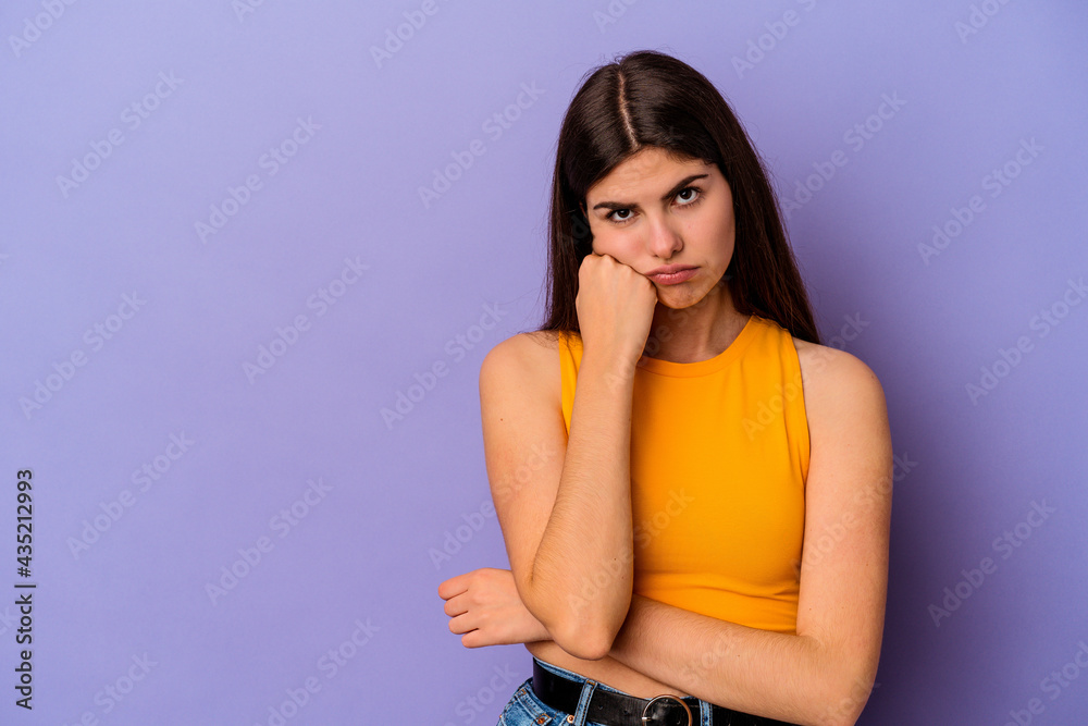 Young caucasian woman isolated on purple background who feels sad and pensive, looking at copy space. Young caucasian woman isolated on purple background who feels sad and pensive, looking at copy space.
