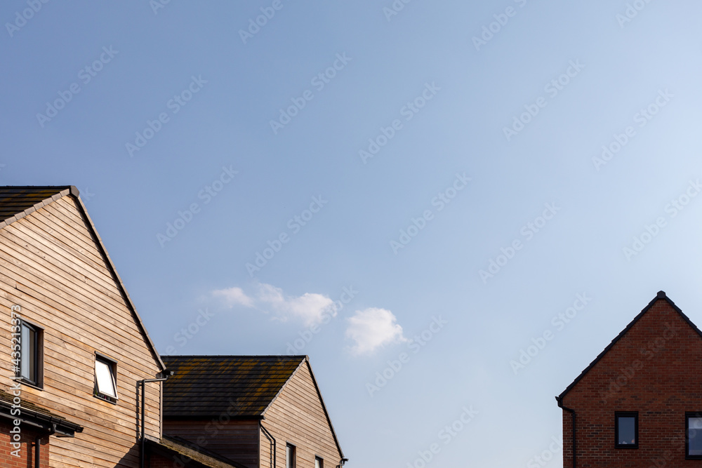 House tops with a large area of clear blue sky and a small cloud. Lots of space for text. Concept of vacation at home. House tops with a large area of clear blue sky and a small cloud. Lots of space for text. Concept of vacation at home.