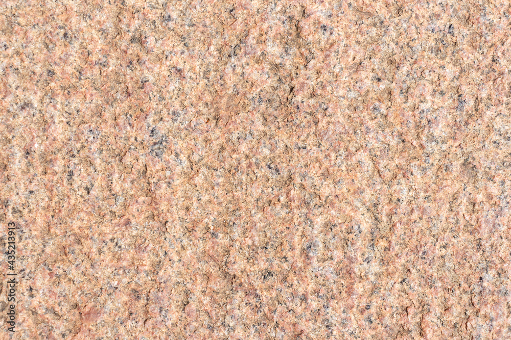 Abstract textured red granite background. Close-up view. Construction industry. Granite is rocks that is composed mostly of coarse-grained quartz and feldspars in varying proportions. Abstract textured red granite background. Close-up view. Construction industry. Granite is rocks that is composed mostly of coarse-grained quartz and feldspars in varying proportions.
