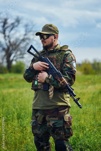 Russian soldier in a military foma holds a weapon in his hands
