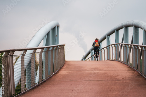 Canvas Print Cyclists on a footbridge in Leverkusen, Germany.