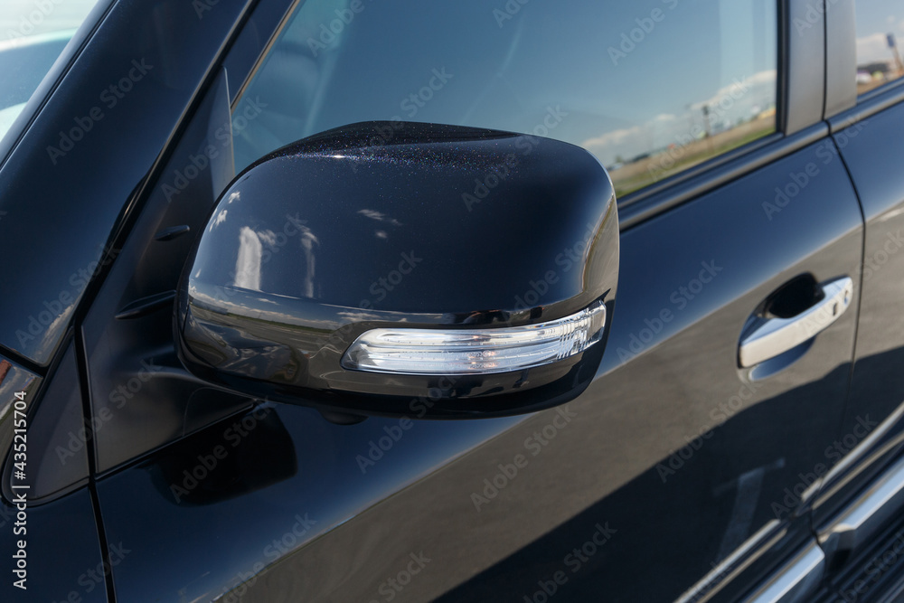 Side car mirror close-up. Details of luxury car. Car detail. Exterior details. Automotive concept. Classic black color