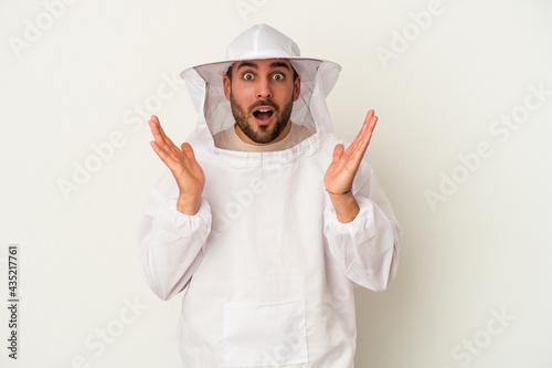 Young apiculture caucasian man isolated on white background surprised and shocked.