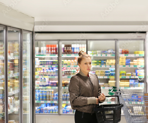 Woman choosing frozen food from a supermarket freezer